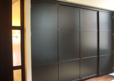 Built-in Wood Cabinet With Sliding Doors and Stone Top for The Dohmen Company Foundation